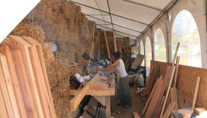 Carole, à la scie pendulaire découpe les montant de l'ossature GREB 2013